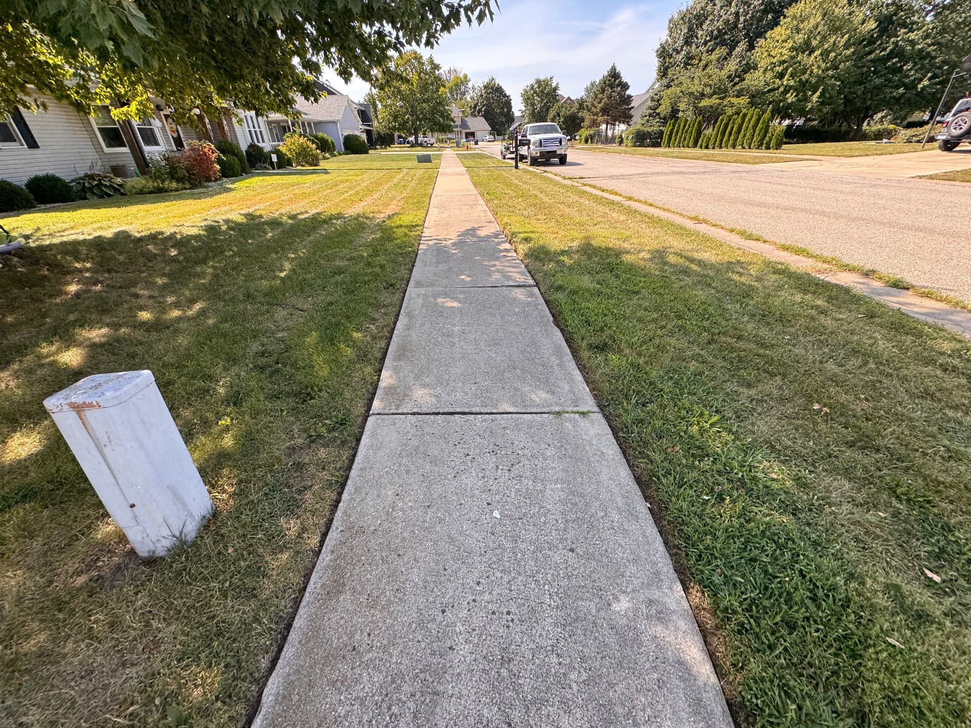 Freshly edged sidewalk with neatly cut grass on both sides