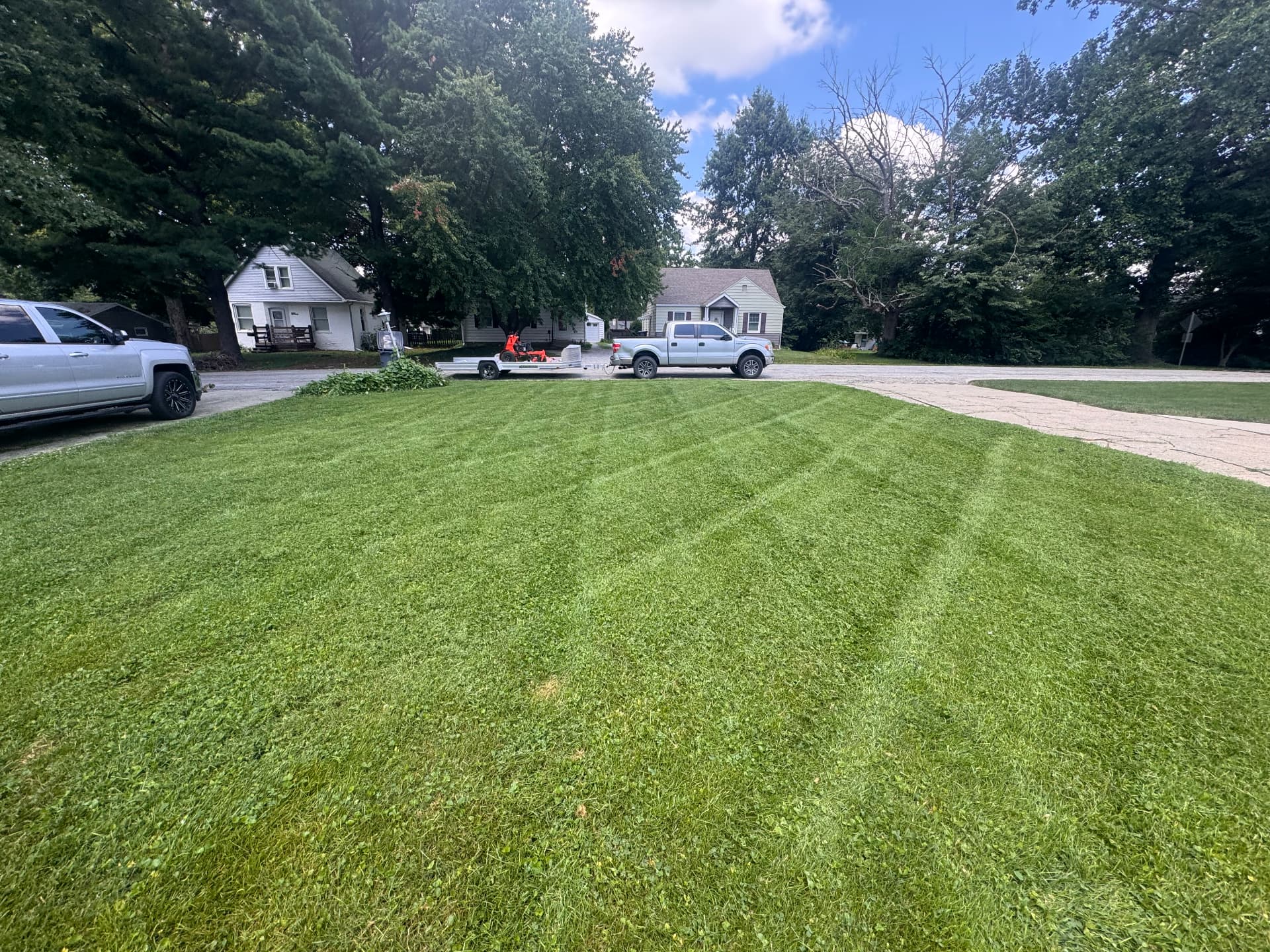 Freshly striped yard with the CCLD truck and mower trailer nearby