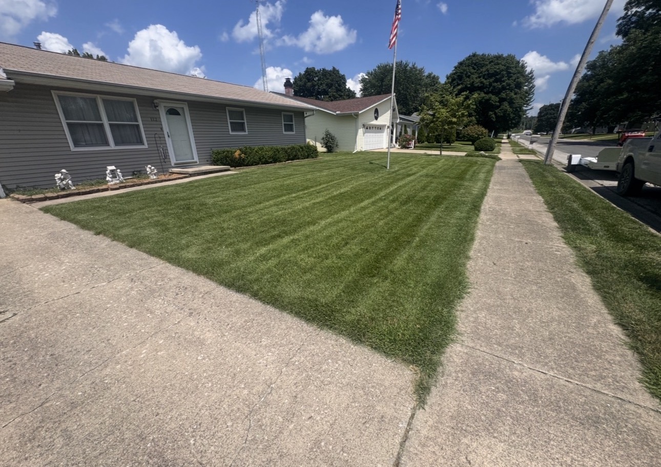 Residential front lawn with crisp stripes beside the sidewalk